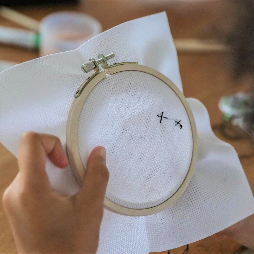 A hand with an embroidery hoop